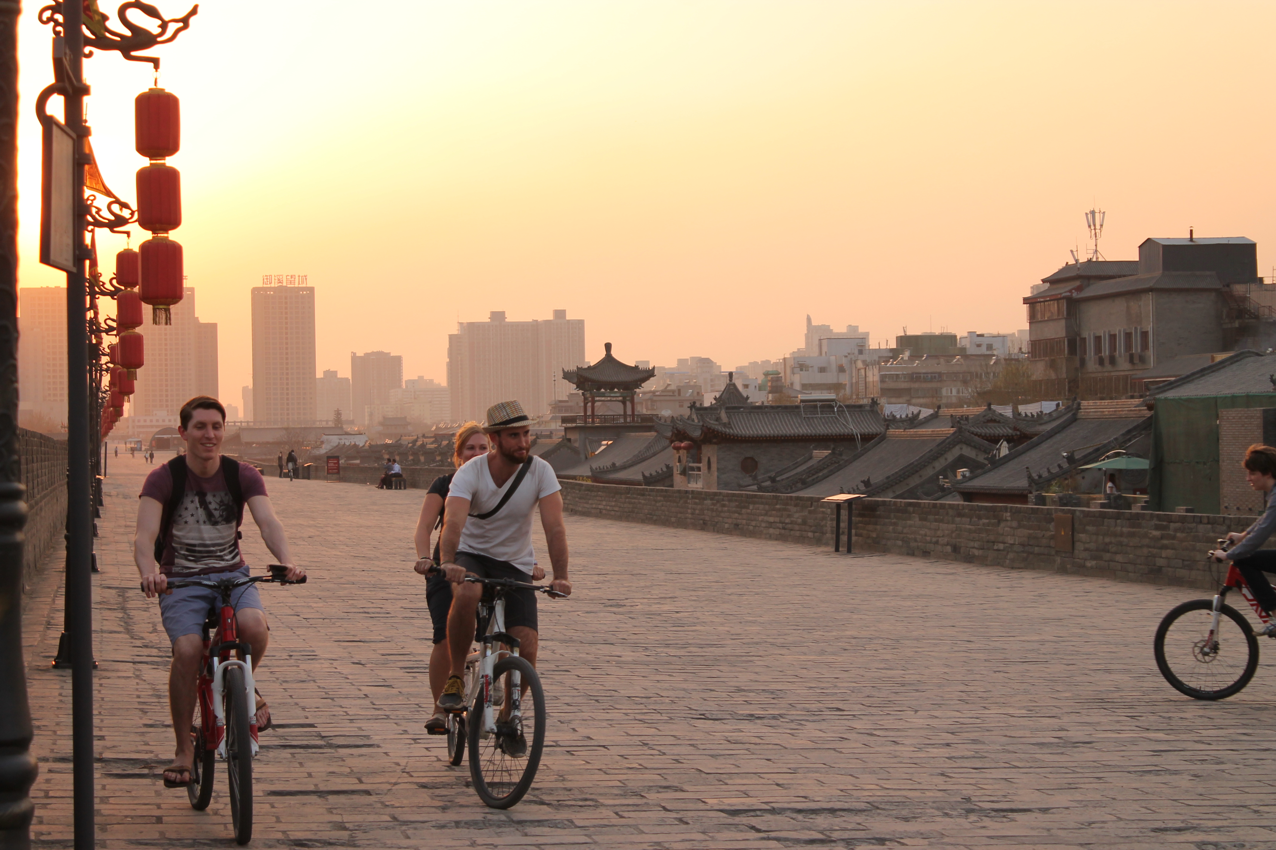 interns riding bikes on the ancient wall of Xi'an