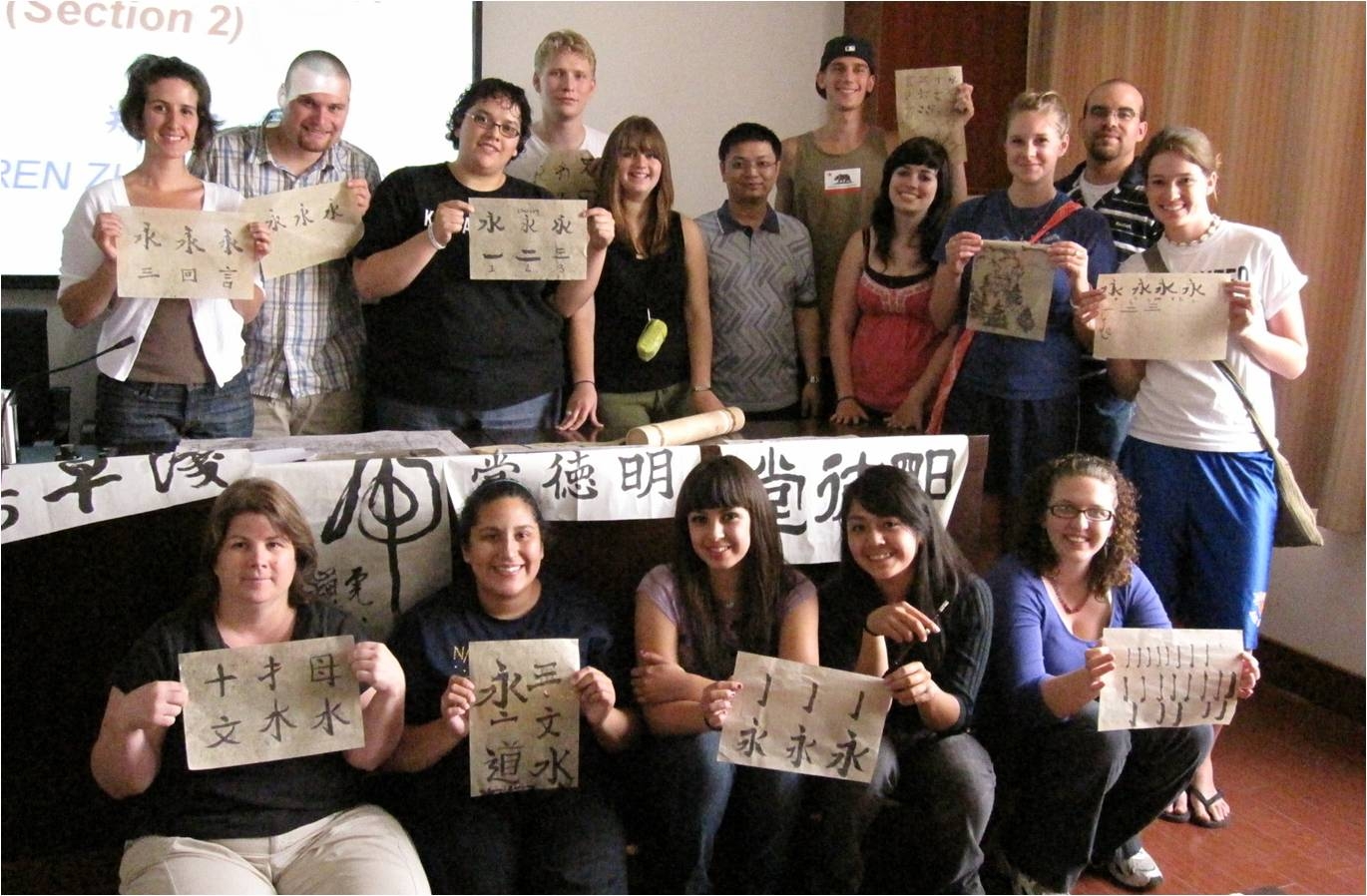 foreign students taking photos with their Calligraphy working in Chinese class in China's university